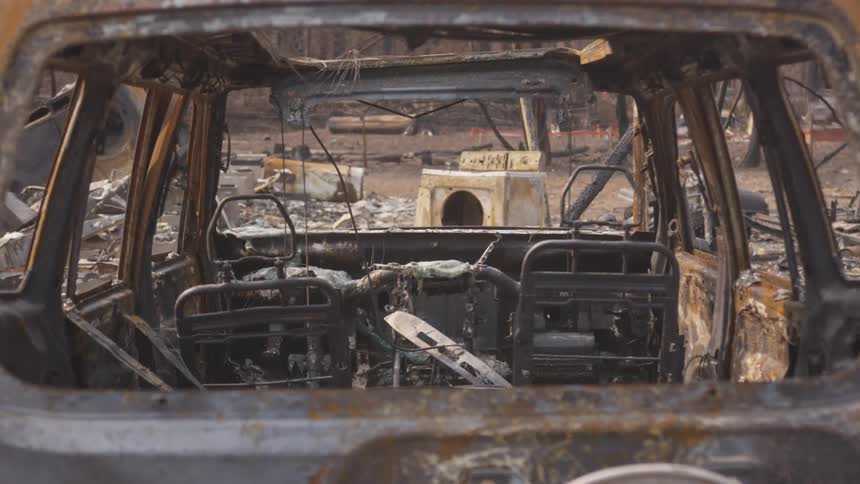 A destroyed completely corroded car and other debris