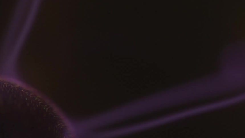 An extreme closeup shows wispy purple filaments of plasma arcing from the central electrode of a plasma ball