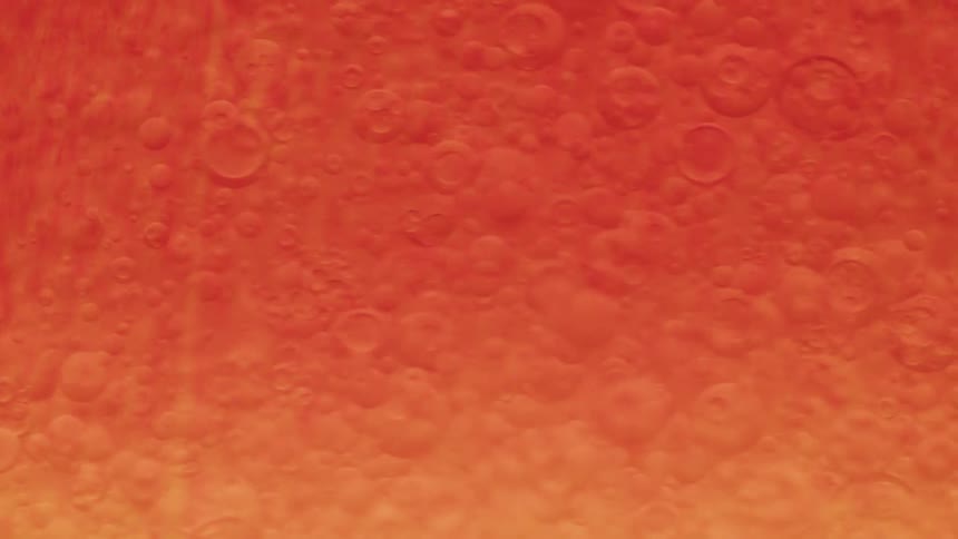 Orange liquid with bubbles in abstract motion