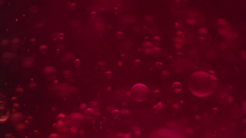 Abstract red liquid with floating bubbles in soft focus