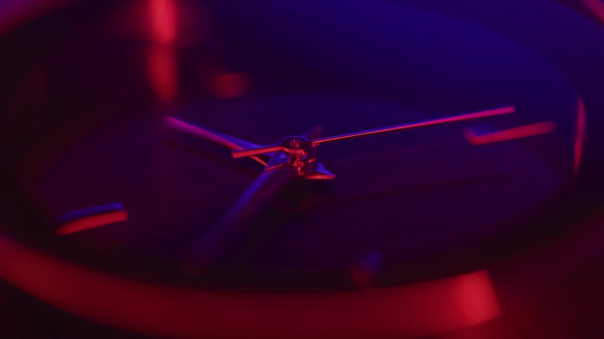 Light reflects on the analog watch dial