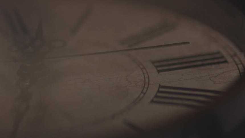 The second hand sweeps over an antique clock face detailed with roman numerals and a map design