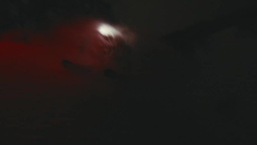 A man snowboards at night