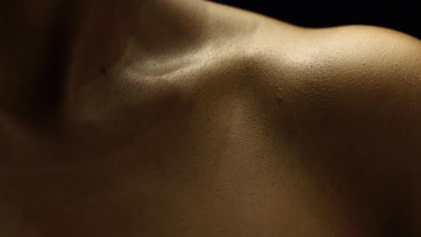 Close up of a dark womans skin on her shoulder and chest area