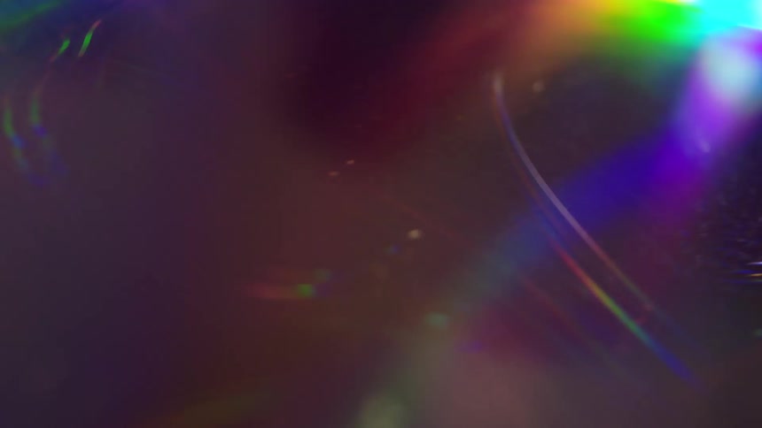 Light reflects onto a compact disc to create a holographic rainbow coloring