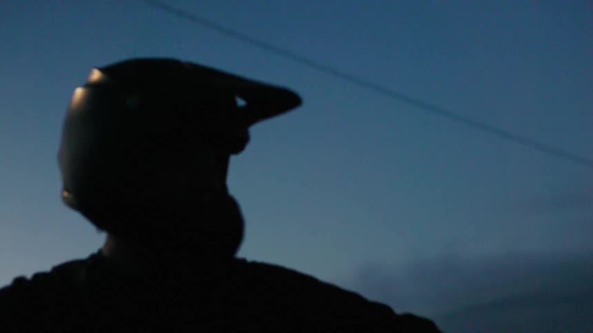 Silhouette of a person with a motocross helmet