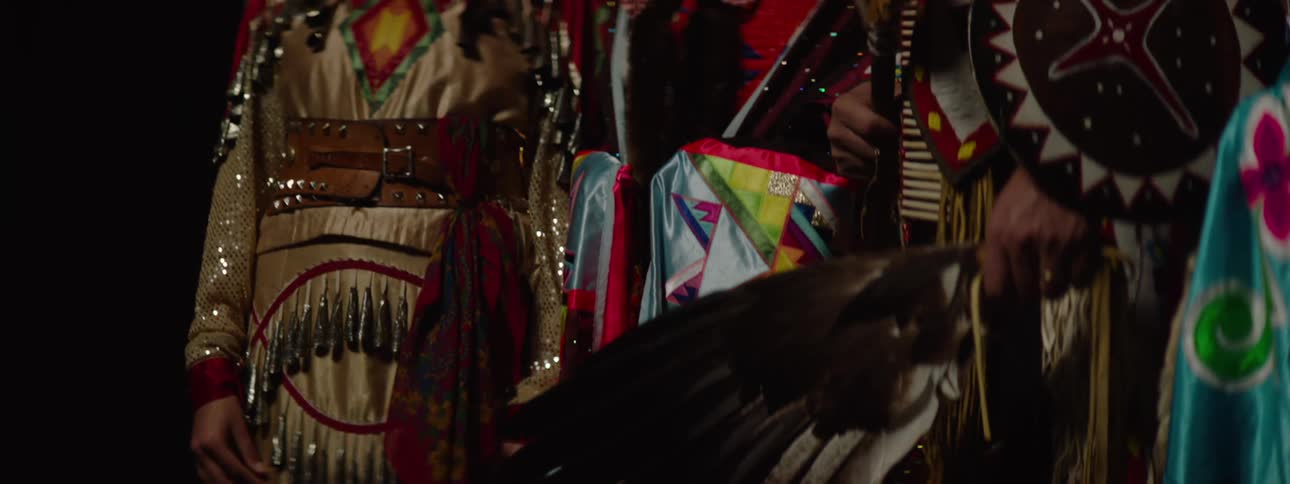 The tribe in costume is posing on stage