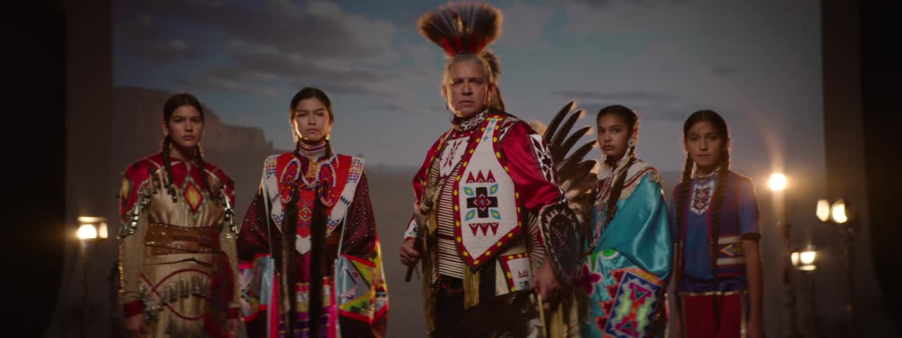 Native american ceremonial performers pose against a photo backdrop