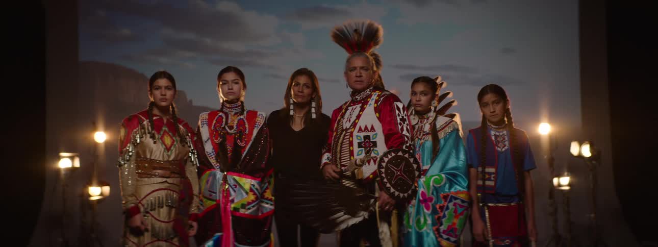 A group of native american indians including a man and several teenage girls all dressed in traditional attire