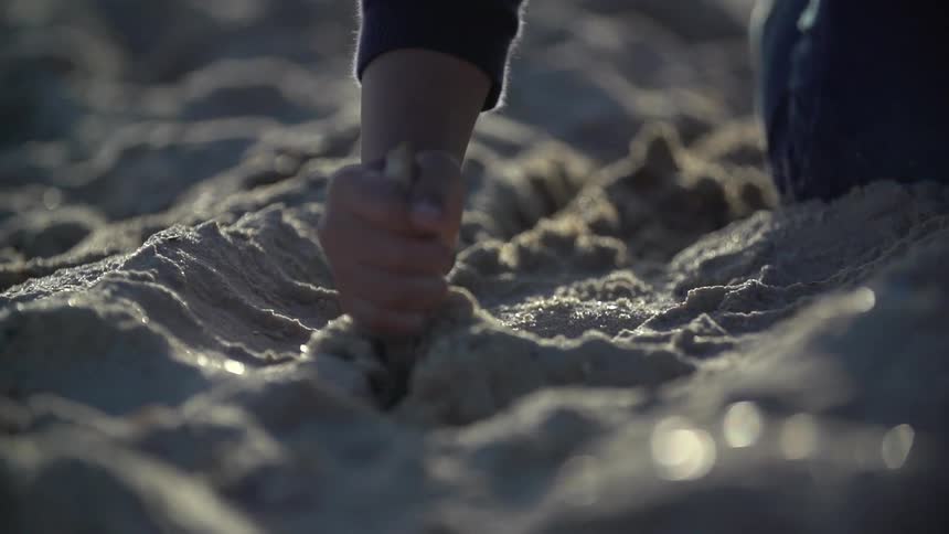 Person digging through sand