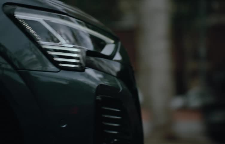 Close up of a vehicle front bumper area as it accelerates through a busy city street during the day