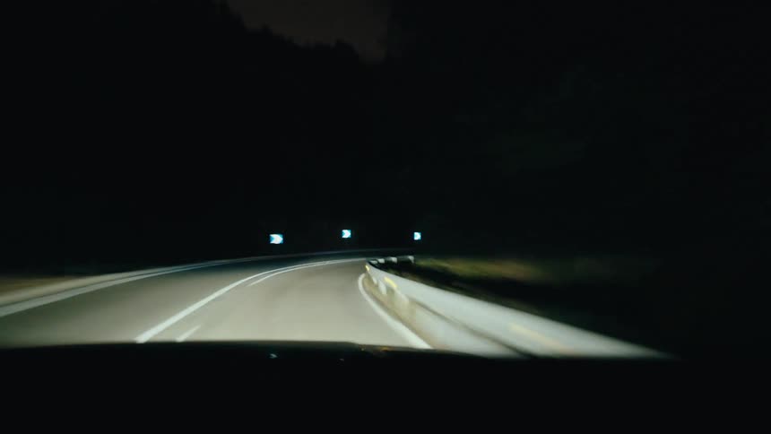 The car is speeding on the winding roads at night