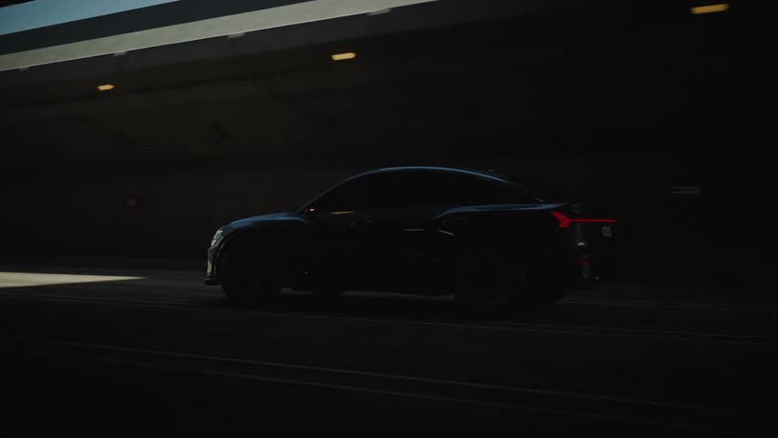 A black car drives through a tunnel