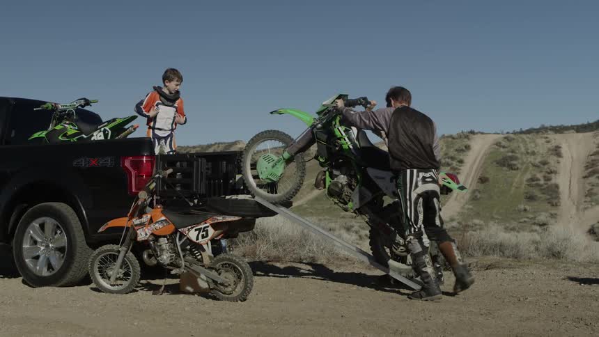 A dirt bike is unloaded from a truck