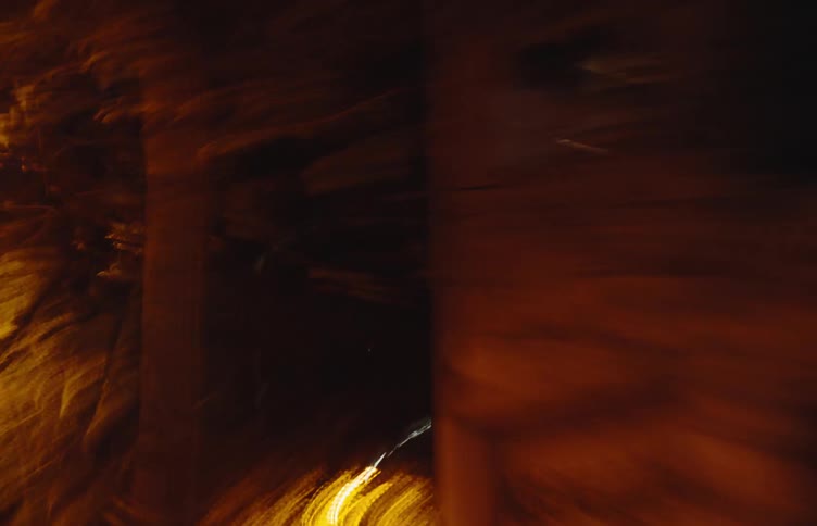 Vehicle with headlights on driving through an urban city at night