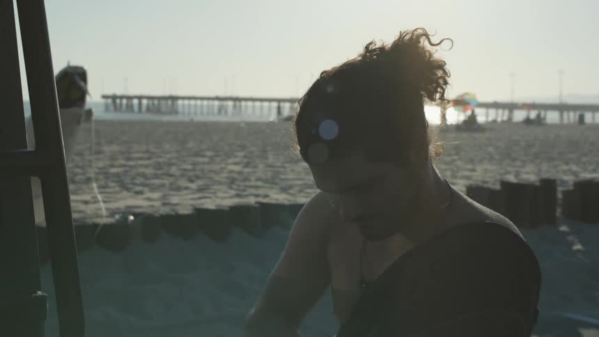 A man puts on a wetsuit on the beach
