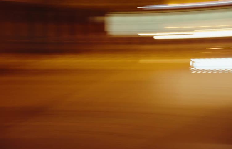A car with bright headlights is driving at night in highly unstable shaky footage