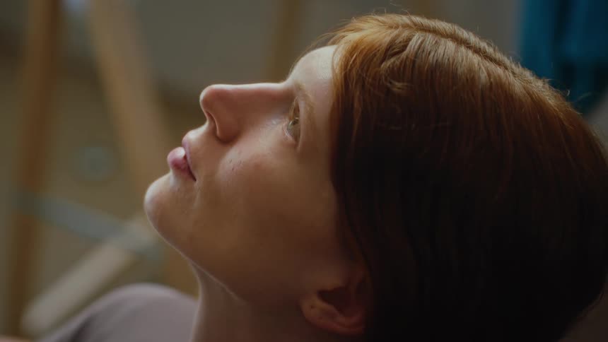 A woman lying down looks back and forth