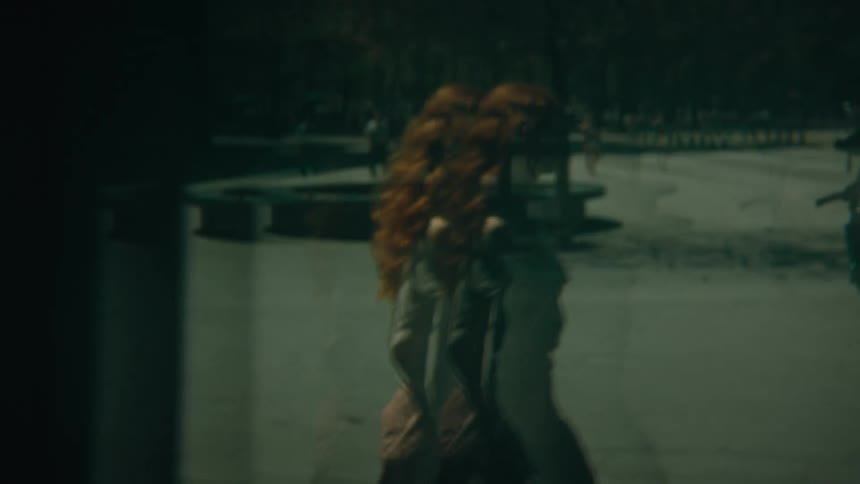 A womans reflection is in the window