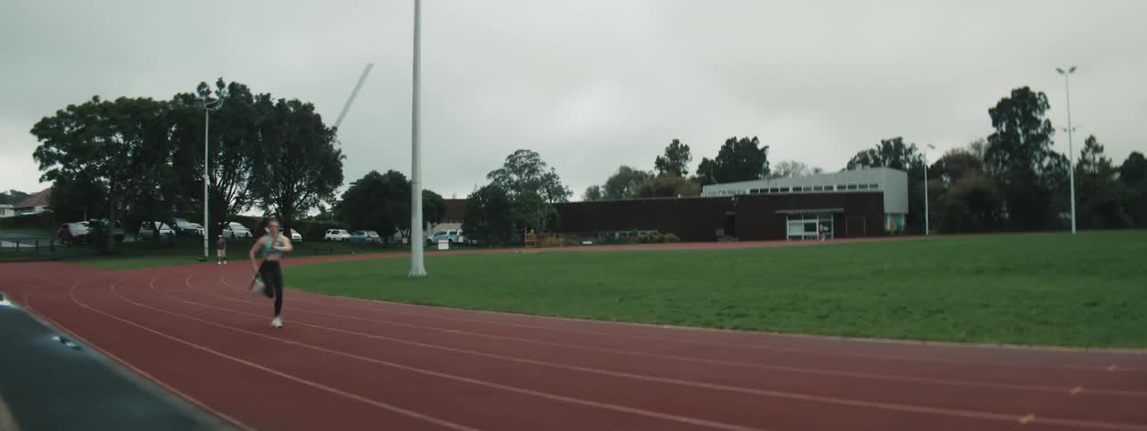 A female athlete runs through the finish line on an outdoor track