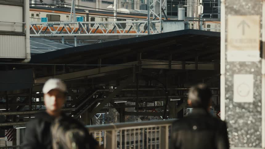 Train passing in the background of pedestrians walking through the city
