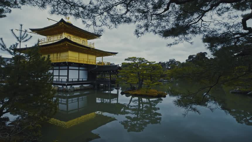 Exterior architecture of an asian temple on the edge of a lake surrounded by trees