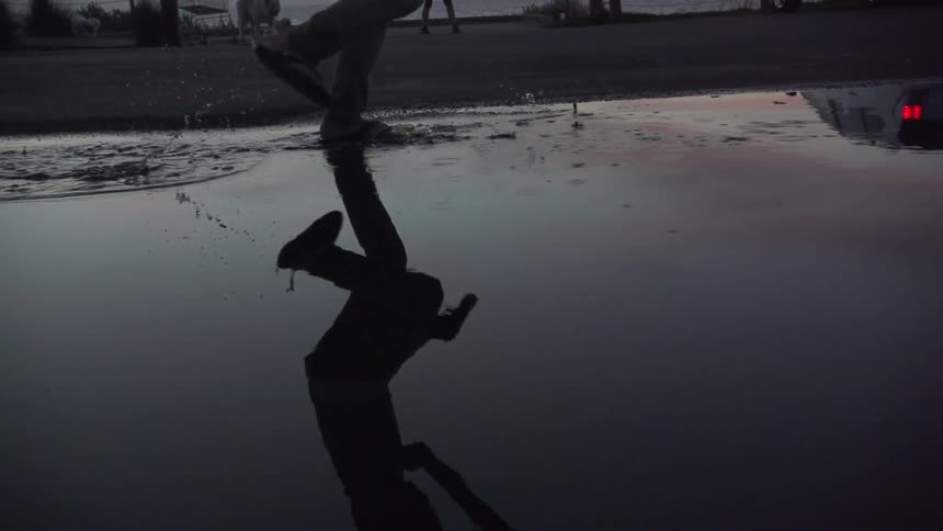 A child walks through a puddle with a gun