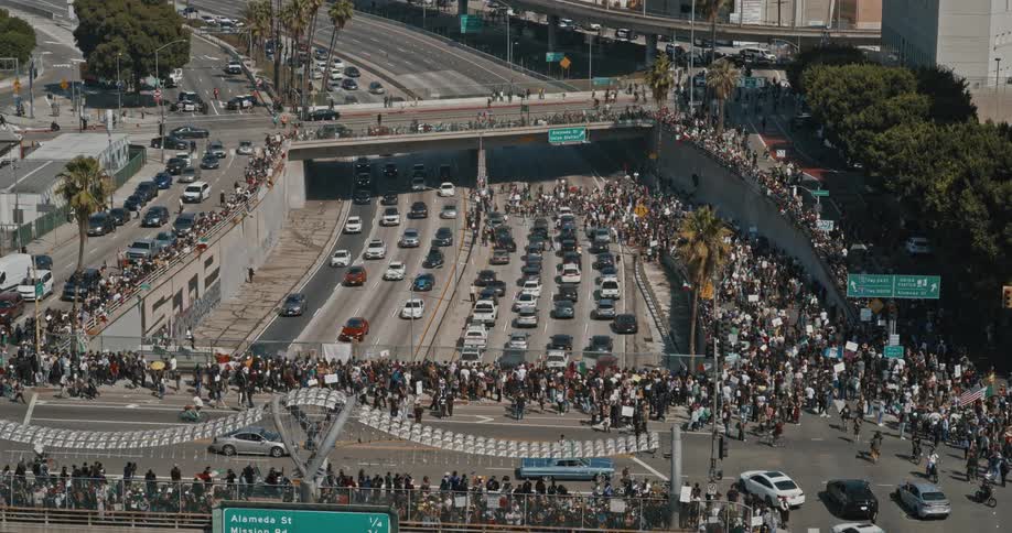 A large crowd of protesters block a highway during a political demonstration