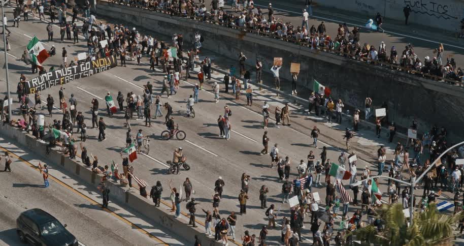 Protesters fill a city freeway holding banners flags and signs during a political demonstration
