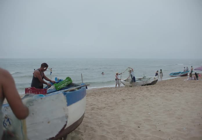 Fishermen and children engage in daily routines along a foggy shoreline capturing a slice of coastal life