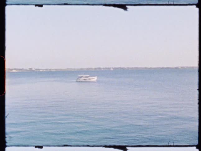 A yacht is in the middle of the ocean on a sunny day