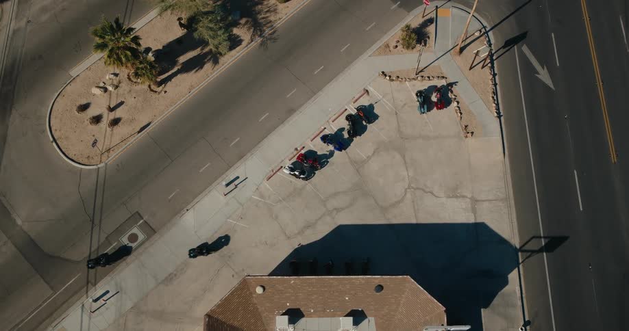 Two motorcycles pull up to the building