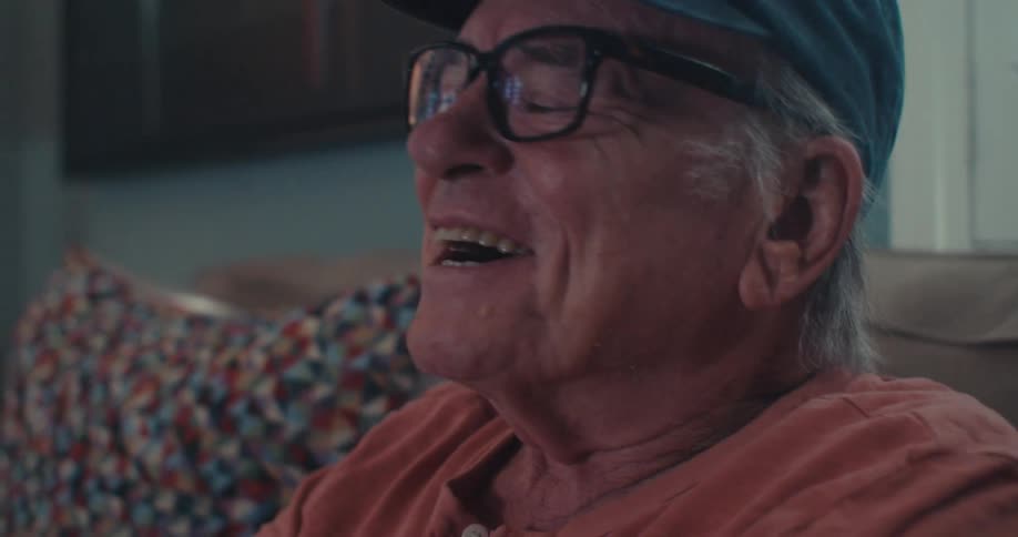 A man is laughing while watching television