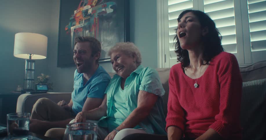 Elderly lady sitting next to two happy young adults