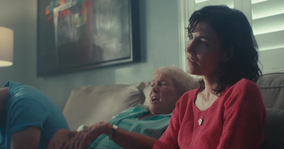 Family of three express disappointment as they sit on a couch while watching tv in a living room