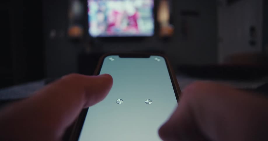 Close up of a person using the zoom feature on a mobile phone while sitting in a living room