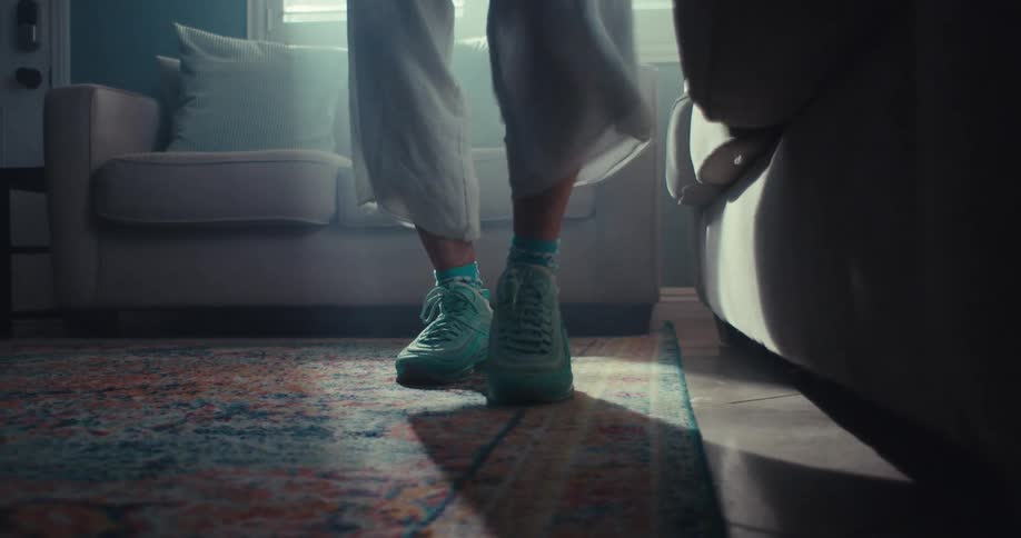 Close up of an elderly womans legs as she walks on the floor rug in a living room