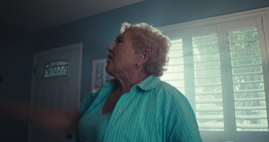 Elderly woman joyfully singing and dancing inside a cozy welllit living room