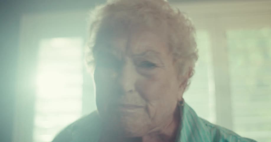 An elderly woman dancing alone and happily inside her home