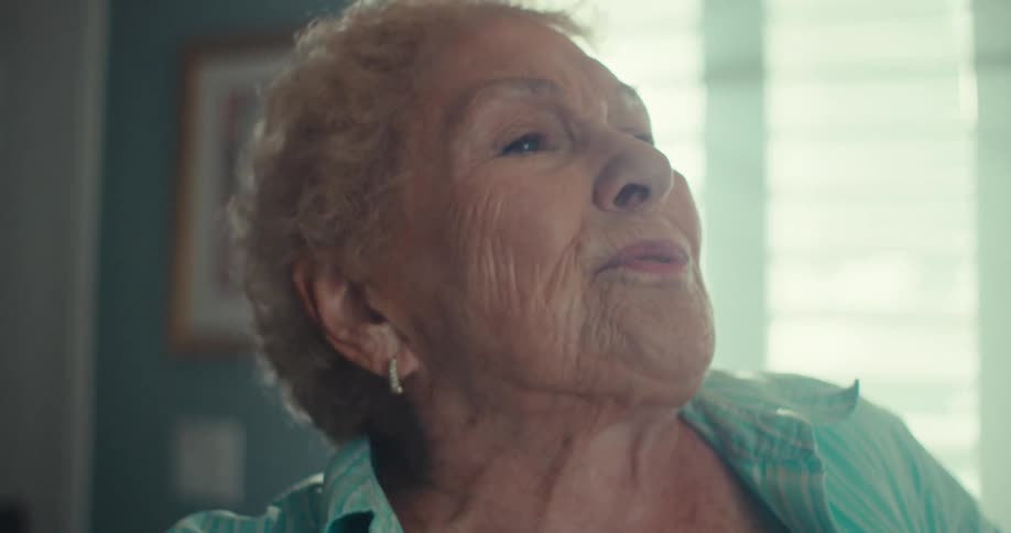Elderly woman sings while she dances at home during the daytime