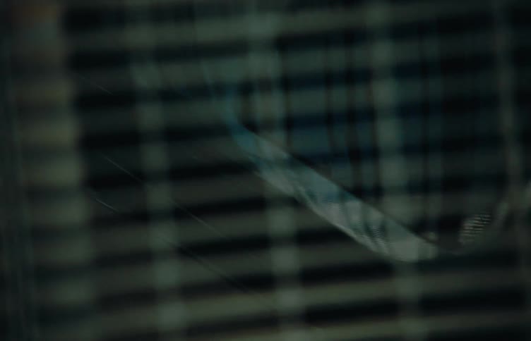 A black vehicle driving under a metallic grid