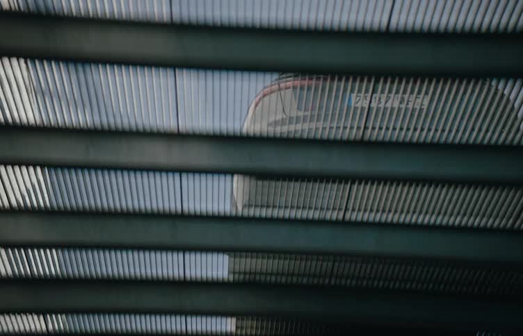 Car moving downwards on a metal slope in a building during daytime