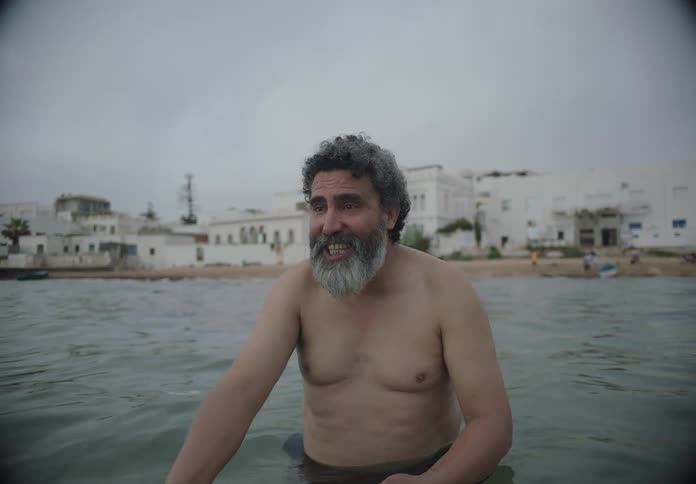 The man is talking on the beach