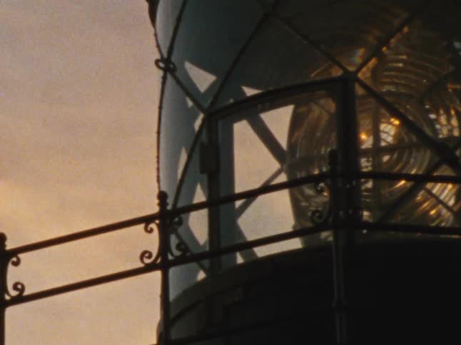 Close up of the top a lit tower on a building at sunset
