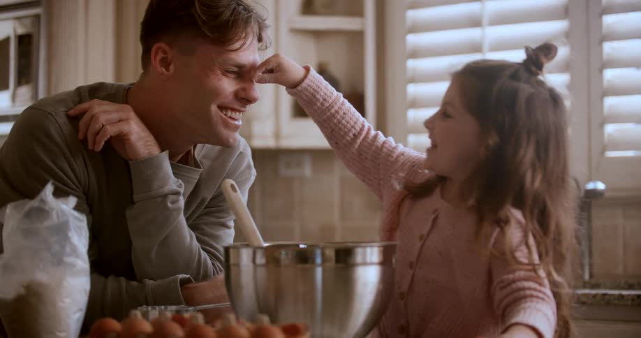 A father and daughter tap each others noses