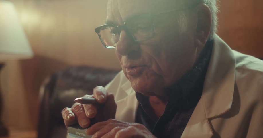The man is holding a brochure and pointing to it with a pen
