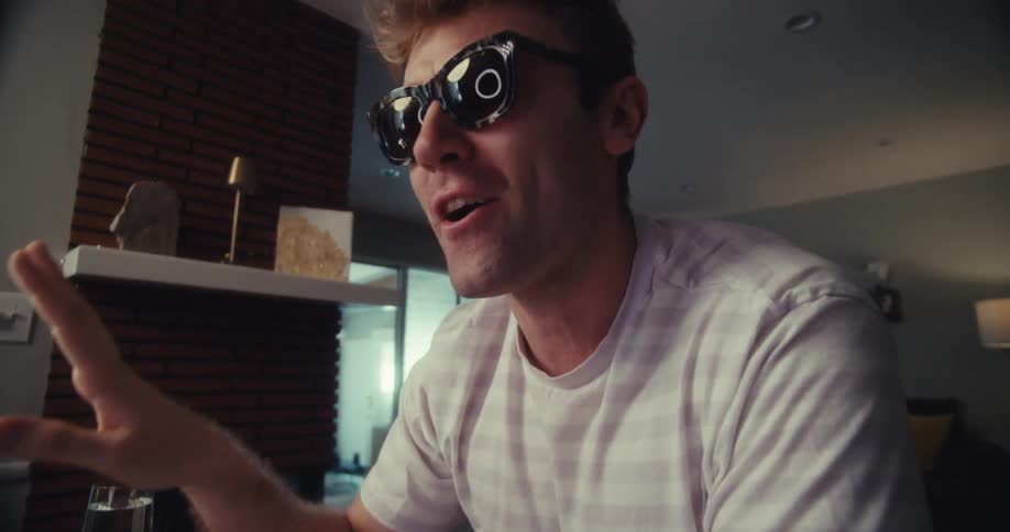 Blond man with glasses talking happily