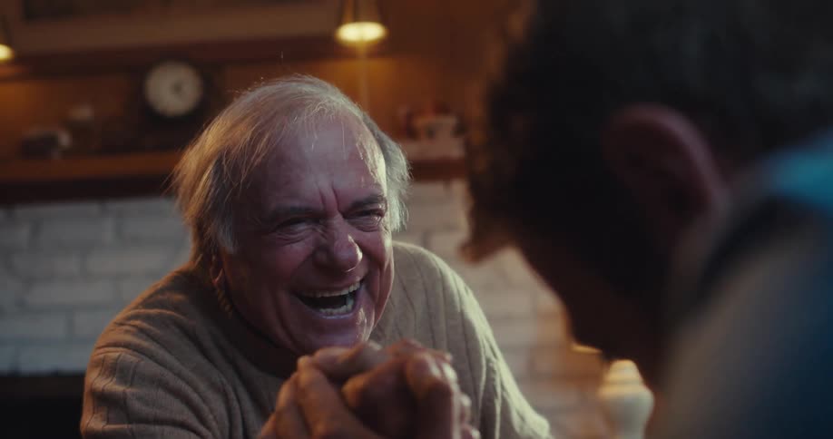 Two men laugh and shake hands