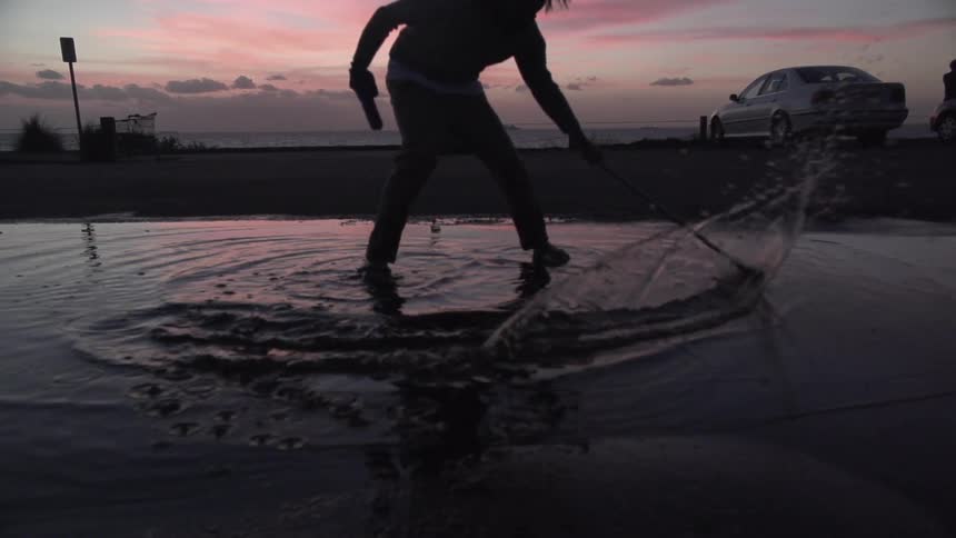 A child holding a gun splashes in a puddle