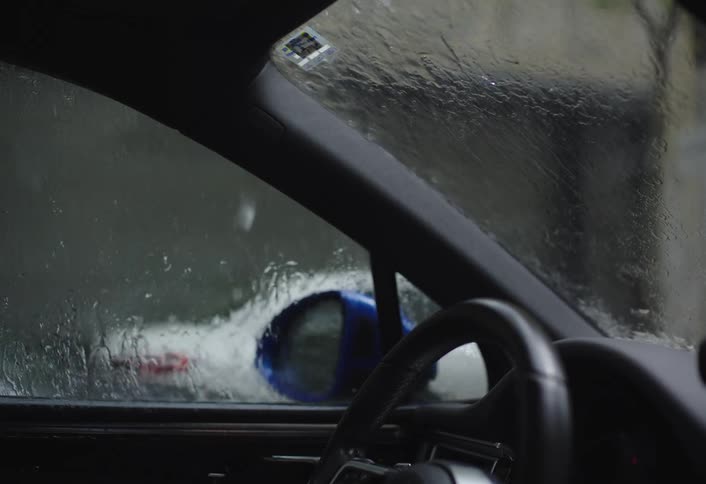 Rain pours on the windshield of the car